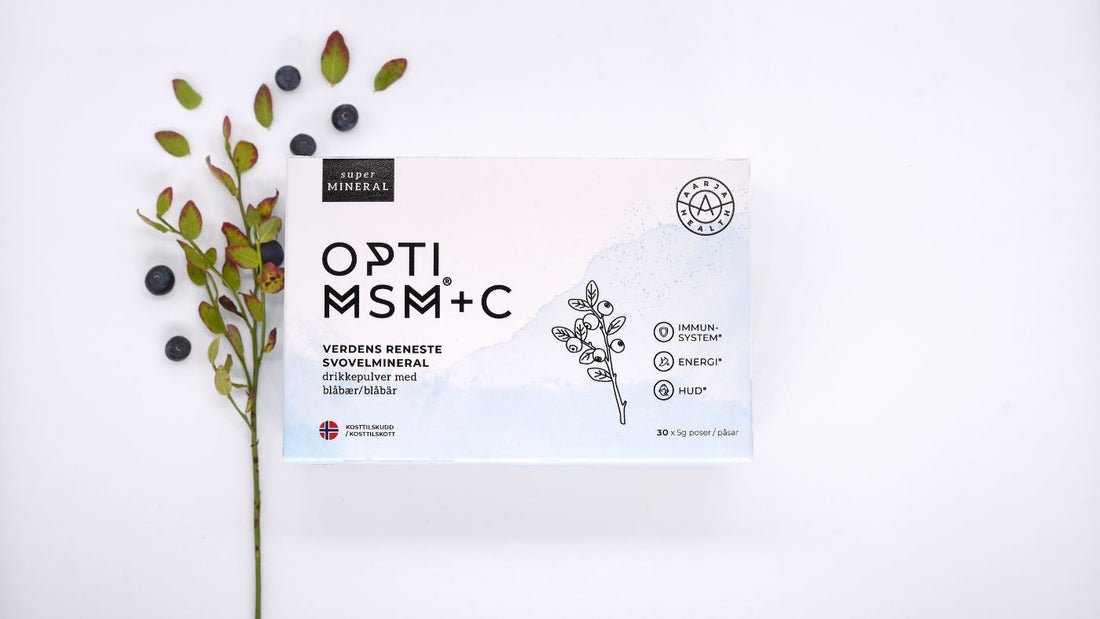 En hvit boks med kosttilskuddet OptiMSM + C vitamin skrevet i svart skrift, med hvit bakgrunn og lyng bak seg.
